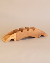 A Ostheimer Bridge With 2 Ramps, handcrafted from sustainably sourced materials, with slots for five knives, displayed on a beige background.