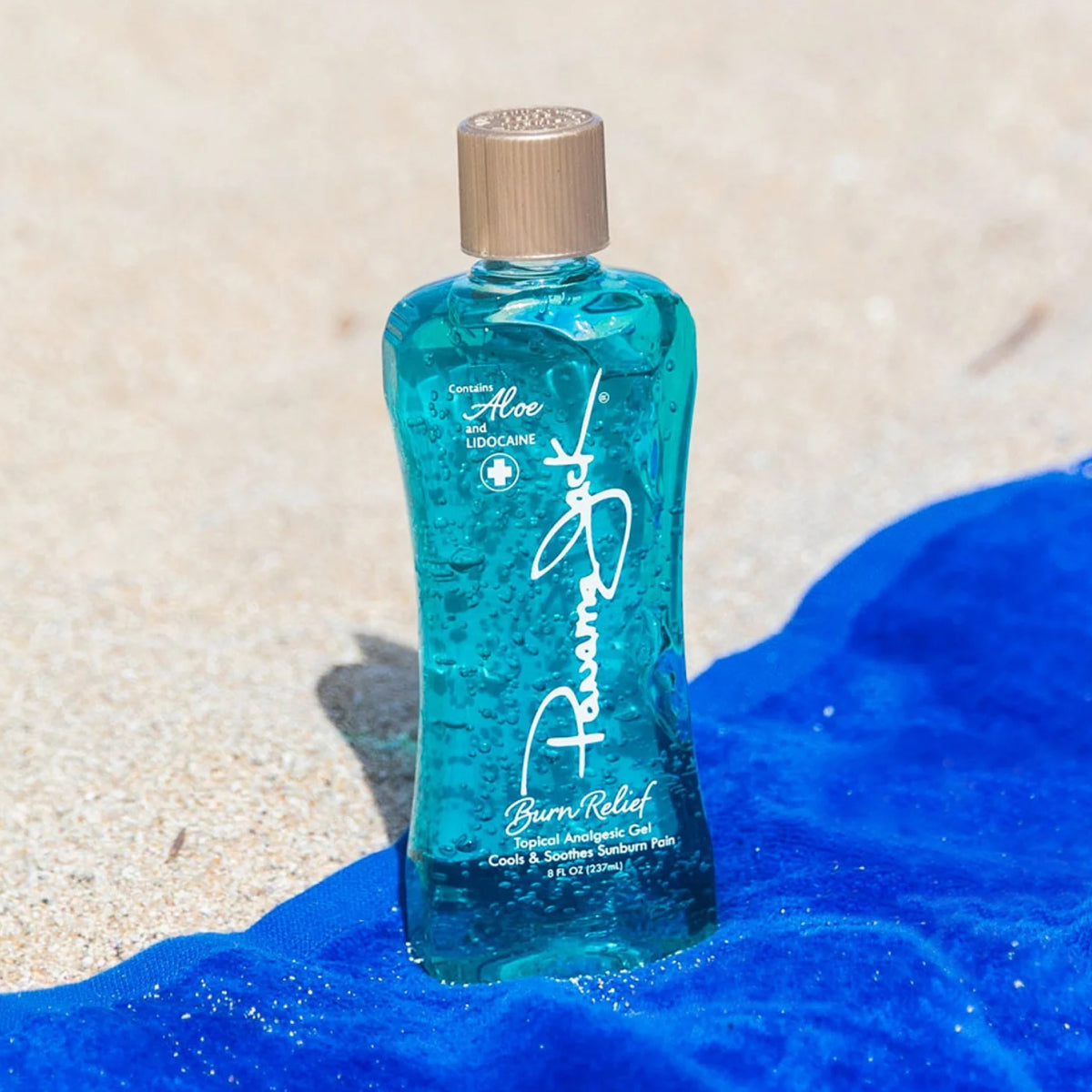 Blue bottle of Panama Jack sun burn relief aloe vera gel on a sandy background