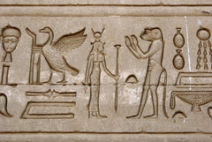 Ancient Egyptian hieroglyphs carved on the wall of Hathor Temple