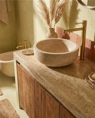 Coppia rubinetti lavabo alto e bidet senza scarico oro in satinato e spazzolato ambientato su piano bagno con accessori...