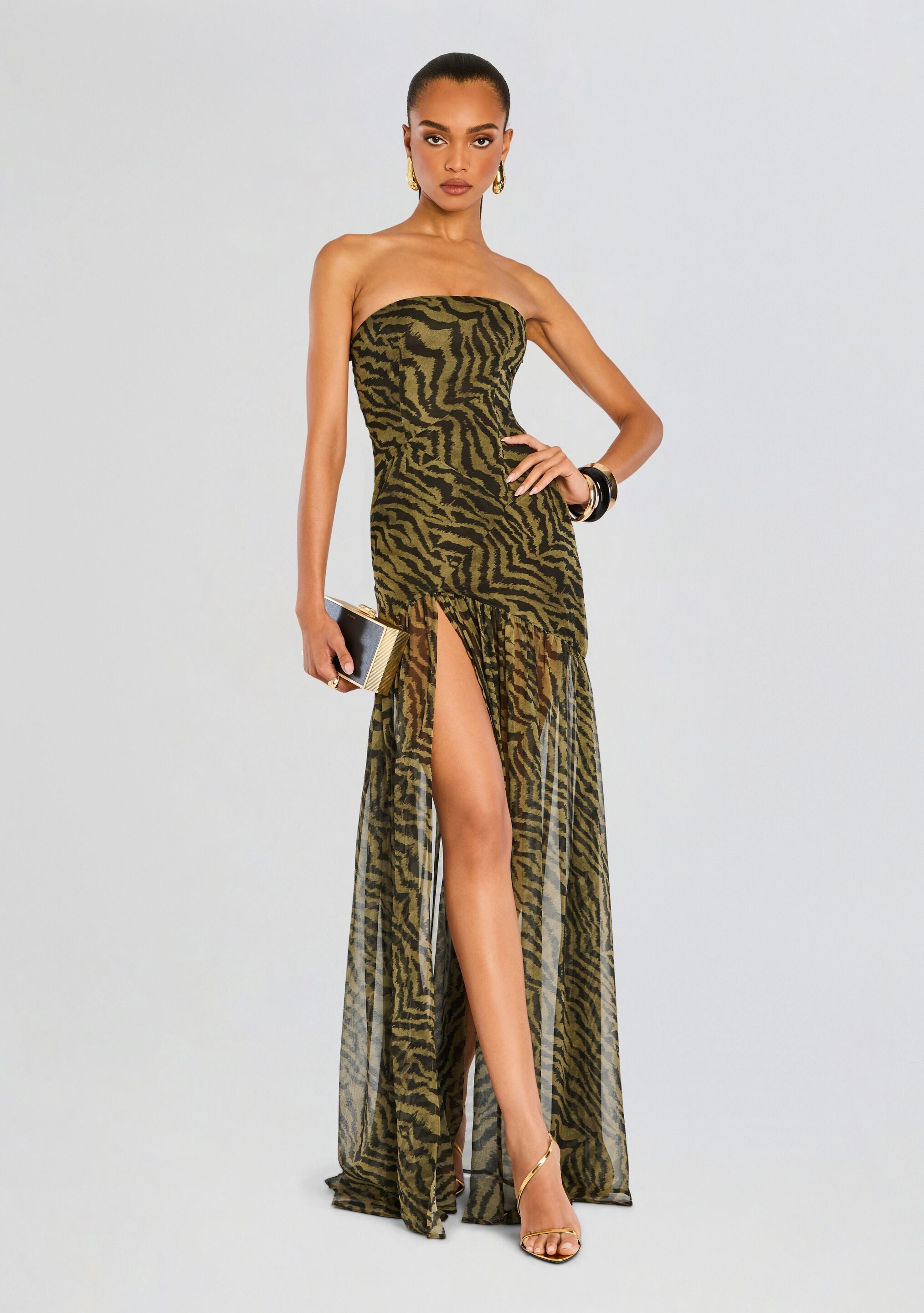 Model in Nicole Silk Chiffon Dress olive and black zebra print with sheer overlay and high slit.
