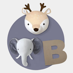 The Animora Deer & Elephant Kids Plush 3D Wall Art by Giant Sculptures features a plush deer head with antlers, a plush elephant head, and a large textured letter B on a round, muted purple background.