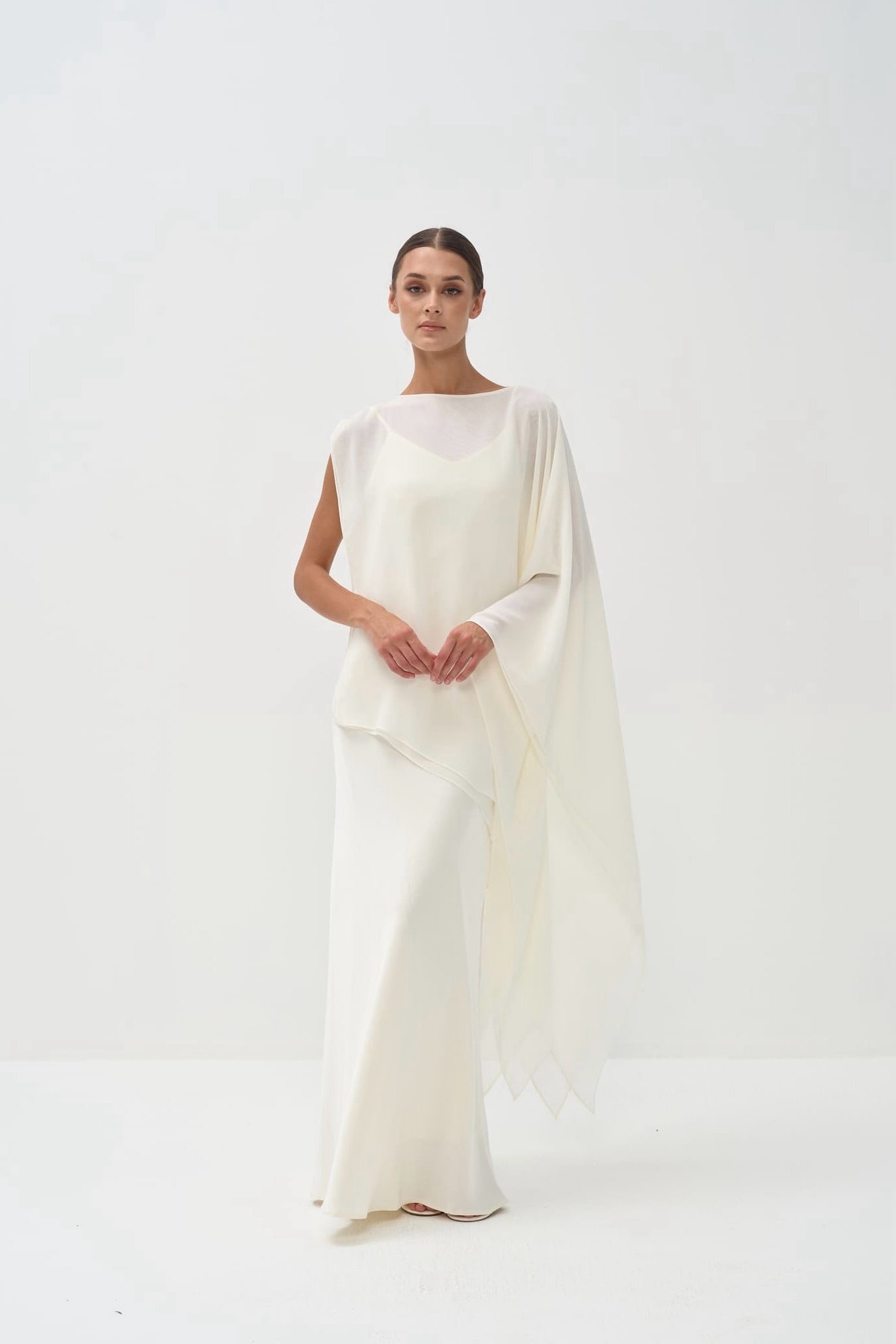 Woman wearing a white dress against a white background