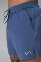 Side View of the Blue the TLF Element Light 7 Inch Shorts featuring side zipper pockets, side split hems and reflective details for nighttime visibility.