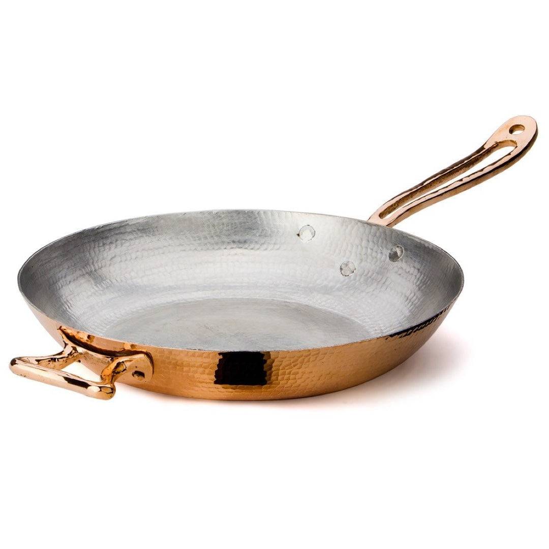 Hand-hammered to perfection by our expert coppersmiths, the 12.5” Fry Pan is a chic cooking staple. Its gleaming copper exterior is complemented by a double layer of tin interior lining. Applied by hand by our artisans, each layer gives the inside of the pan an even protective coat that guarantees a lasting cookware piece.