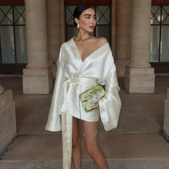 Satin mini wrap dress with large sleeves, paired with rhinestone clutch, evening look