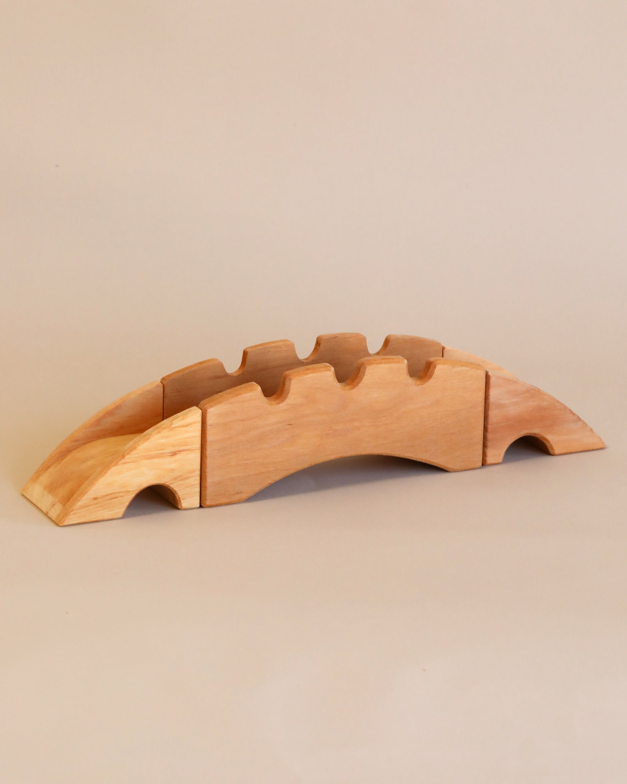 A Ostheimer Bridge With 2 Ramps, handcrafted from sustainably sourced materials, with slots for five knives, displayed on a beige background.