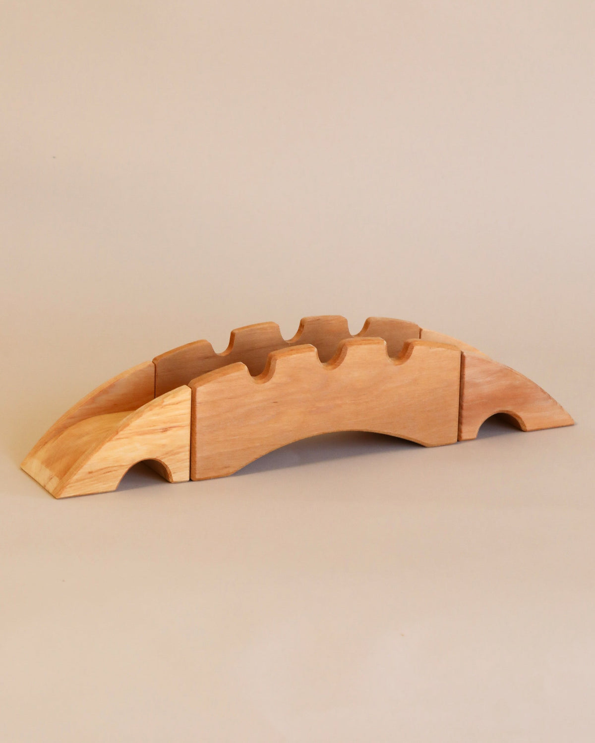 A Ostheimer Bridge With 2 Ramps, handcrafted from sustainably sourced materials, with slots for five knives, displayed on a beige background.