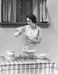 1920s 1930s woman pouring milk into measuring cup