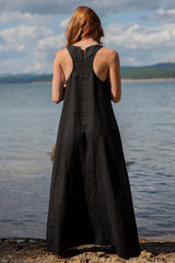 Minimalist long linen sleeveless black maxi dress with halter back silhouette by the water