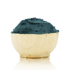 Wooden bowl filled with green powder on a white background