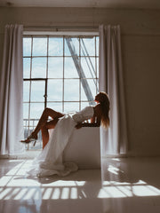 A model poses in a Corset Basque Waist Wedding Dress with Slit
