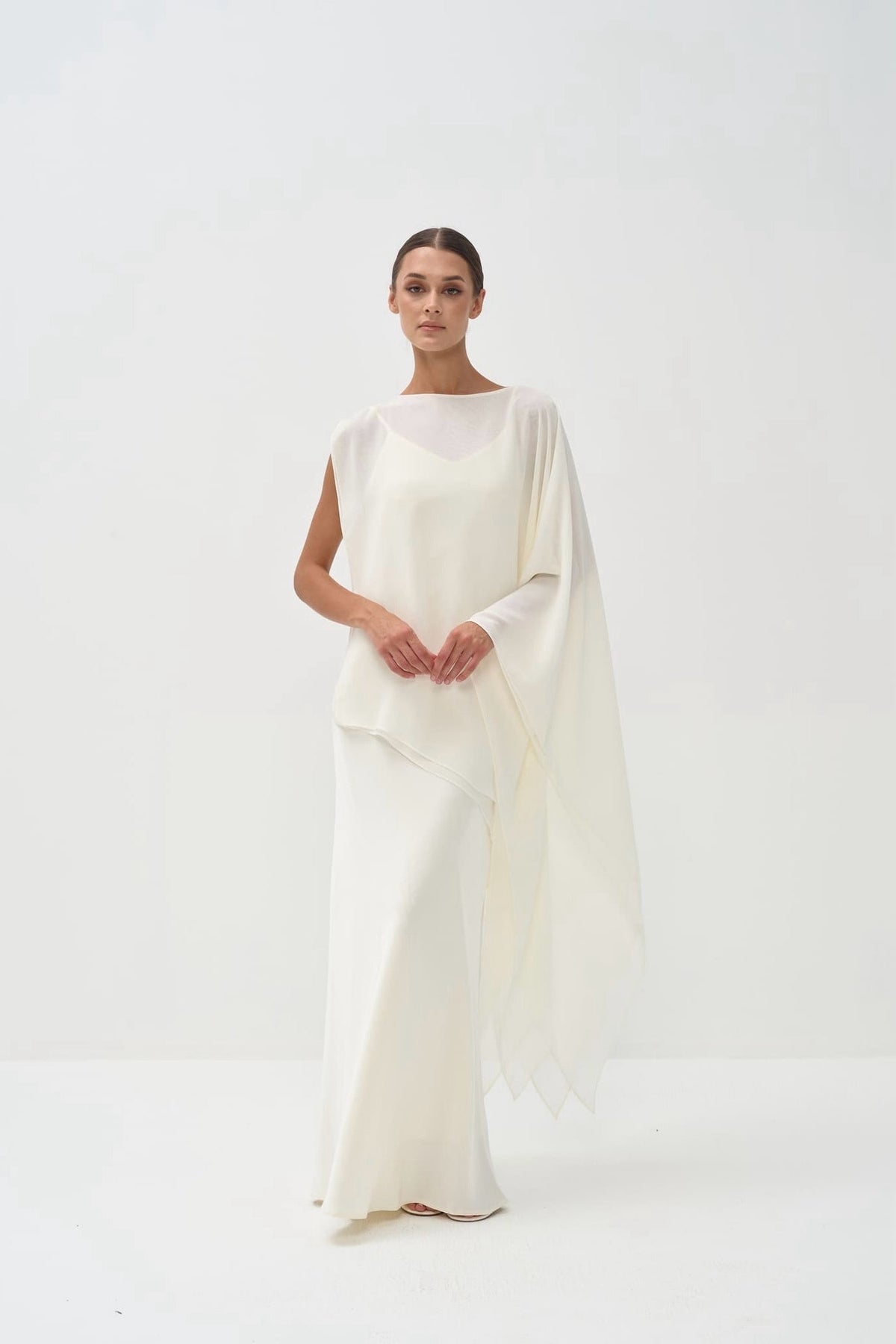 Woman wearing a white dress against a white background