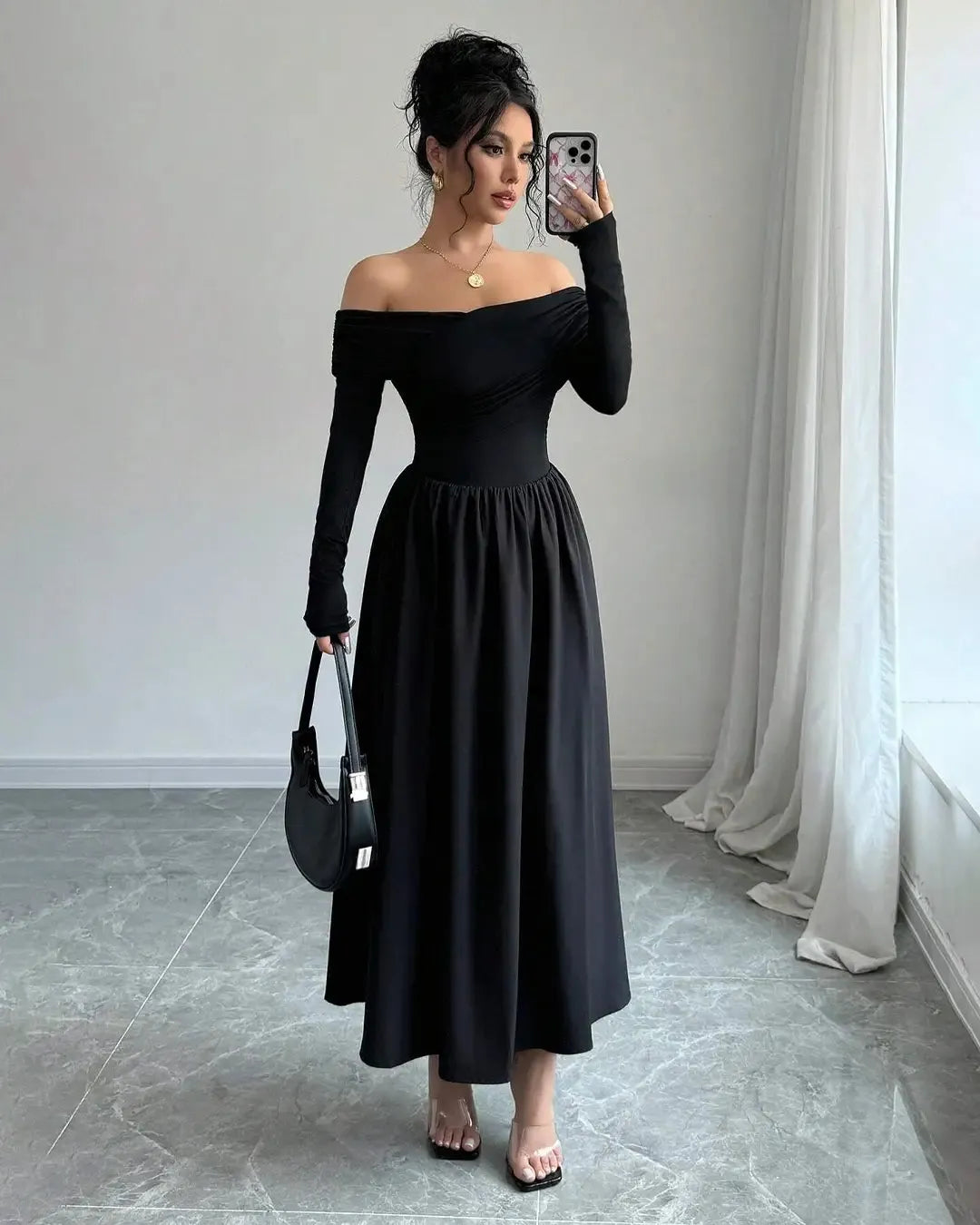 An elegant black off-the-shoulder pleated long-sleeve maxi dress, showcasing a sophisticated style
