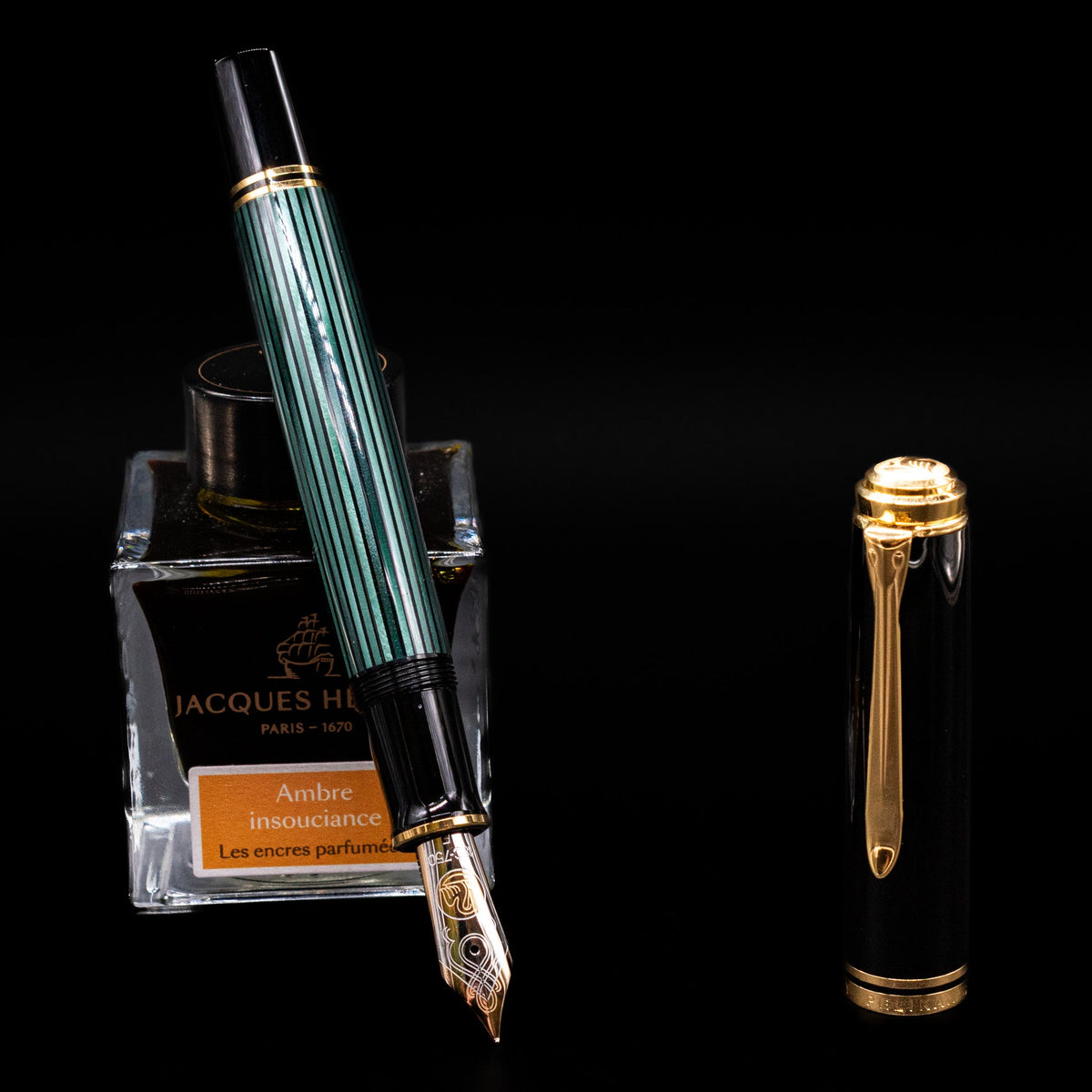Pelikan Souveran M1000 Fountain Pen - Black & Green leaning on an ink bottle uncapped showcasing the detailing on the nib.