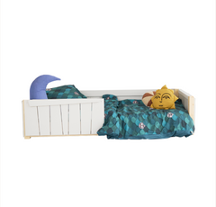 A toddler-sized white floor bed with teal leaf-patterned bedding and stuffed animals.