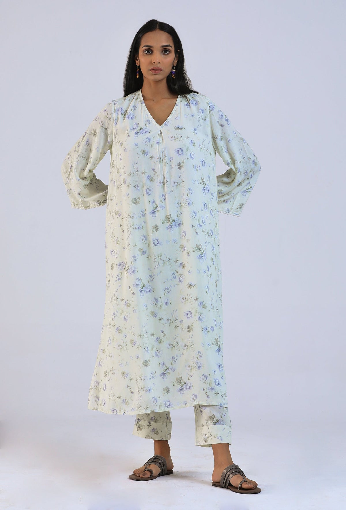 Model wearing off white viscose cotton kurta with conifer floral print and matching pants, front view.