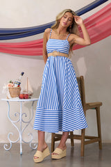 This blue midi dress features a square neckline, thin adjustable straps, a smocked back insert, functional hip pockets, and horizontal & vertical stripes.