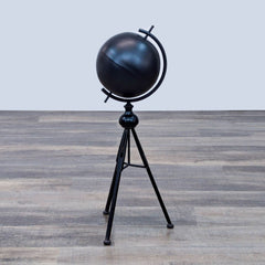 Black spherical globe on a tripod stand with a minimalist design.