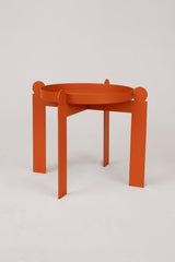 The Palla Multipurpose Plant Stand from Upton is a decorative steel plant stand or fruit bowl with a modern design. Shown here in the burnt orange color, on a white background.