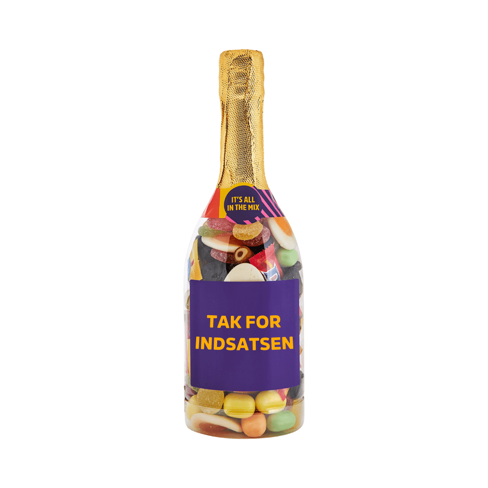 Champagneflaske fyldt med farverigt slik og teksten TAK FOR INDSATSEN på etiketten. Gaveidé fra SlikEkspressen. 
